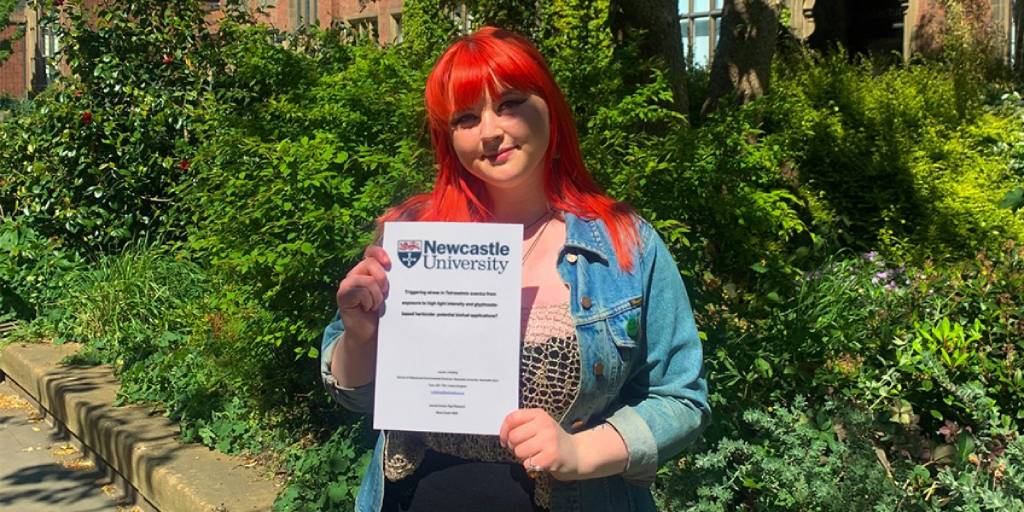 Newcastle Uni student Lauren proudly showing off her dissertation